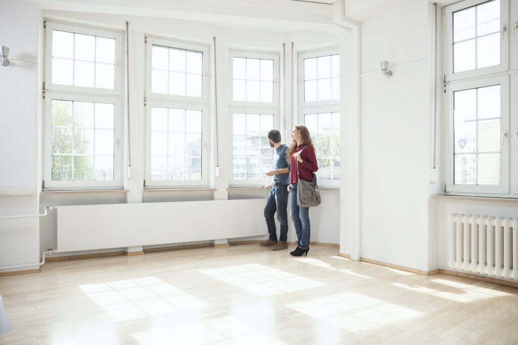 Couple looking around in empty apartment