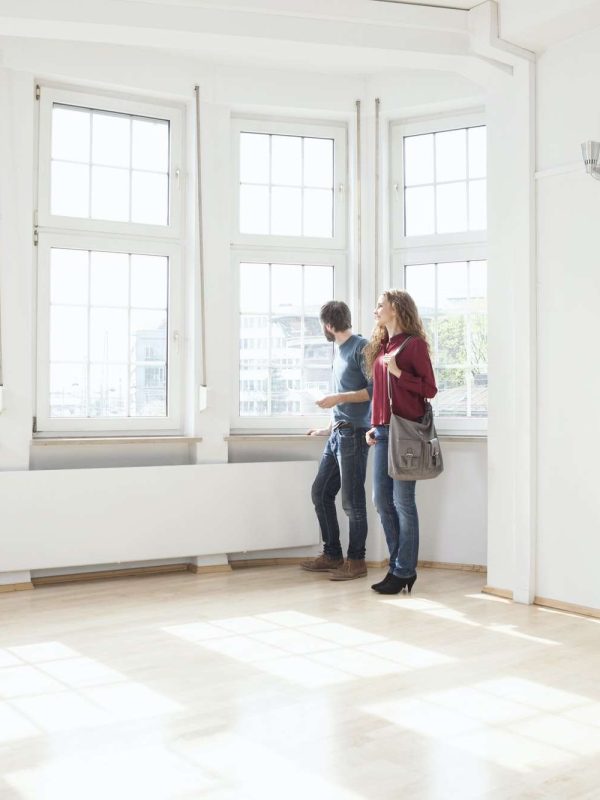 Couple looking around in empty apartment